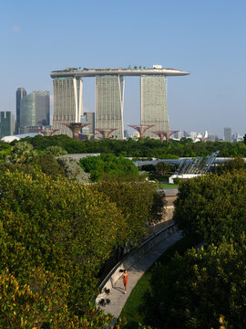 Woman jogging with Marina Bay Sands overlooking Marina Barrage
