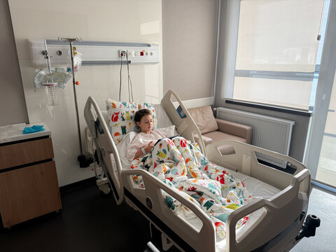 Child resting in hospital bed during medical recovery