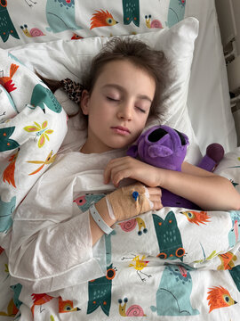 Child asleep in hospital bed after general anesthesia