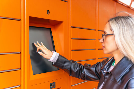 Woman use touchscreen parcel locker for package collection
