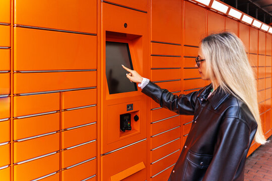 Woman use touchscreen parcel locker for package collection