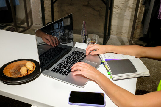 Hands working on laptop at creative workspace
