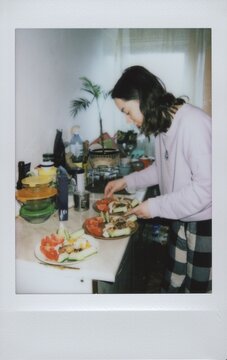 A young woman prepares healthy meals in a cozy home kitchen.
