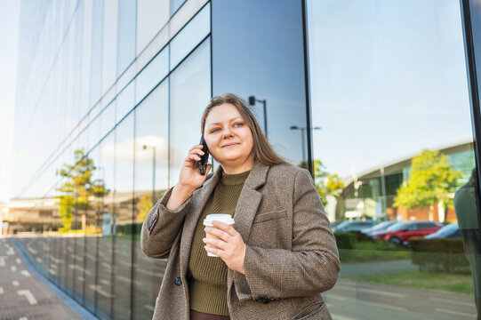 Businesswoman on smartphone call outside modern office building