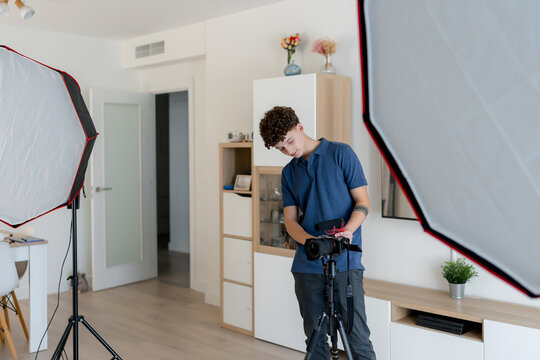 Content creator adjust camera in home studio setup