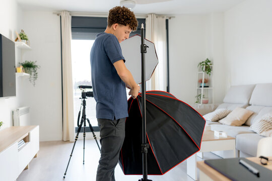 Content creator set up studio light equipment at home