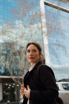 Woman Stands Outside a Modern Building in an Urban Area