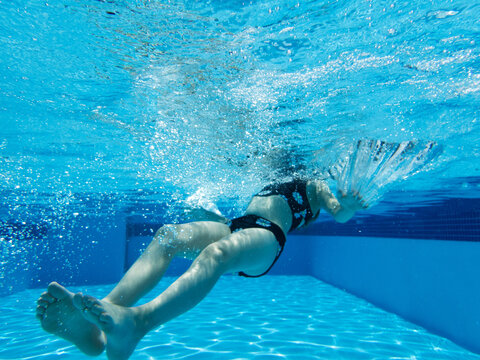 Underwater image of a young girl floating beneath the water