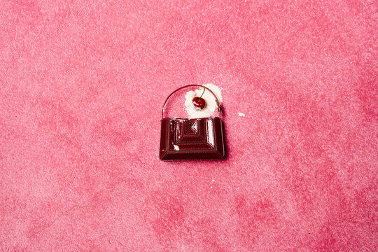 Burgundy Handbag With Cherry On Pink Background