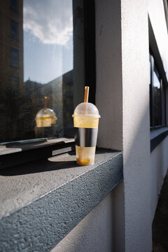 Smoothie in plastic cup on urban window sill