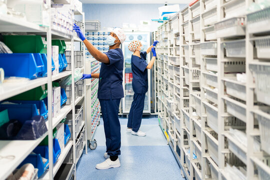 Medical staff organizing supplies in hospital pharmacy storage