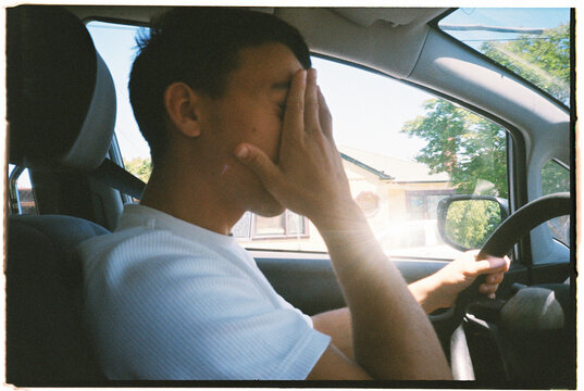 Teenager Driving Covering Face