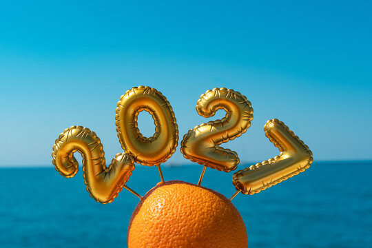 Golden balloons floating above orange against blue background
