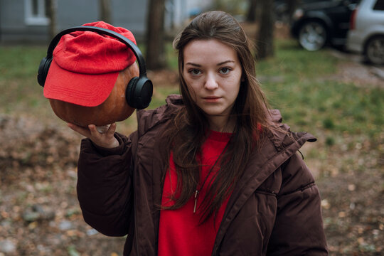 Teenager girl in red cap with headphone in autumn