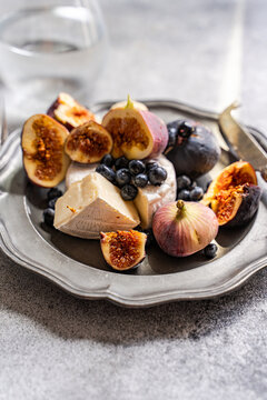 Fig and brie cheese platter with blueberry and water