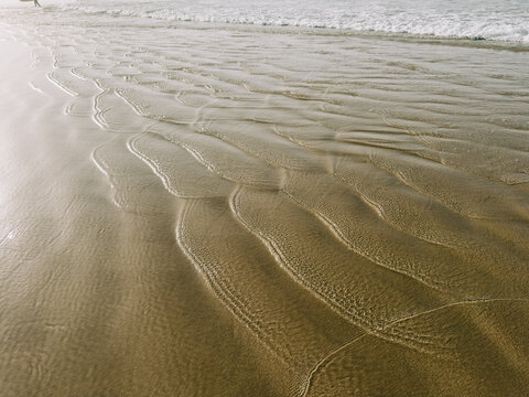 Gentle tidal patterns on a tranquil sandy shoreline