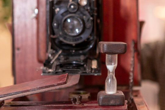 Vintage film camera with hourglass on wooden case