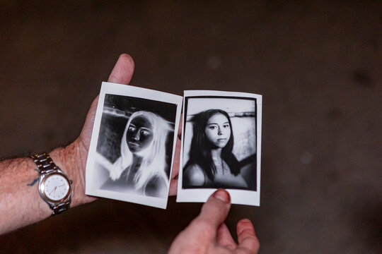 Hand holding vintage film portraits with negative effect