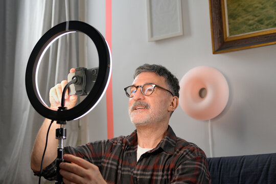 Mature man adjust ring light for remote work video call