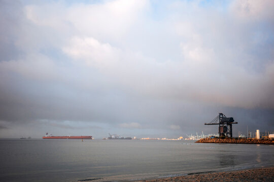Gibraltar harbor with cargo ship under dramatic cloudy sky