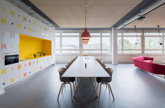 Modern coworking office with communal table and colorful lounge