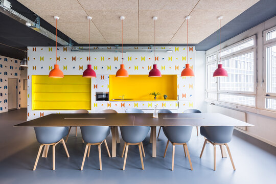 Colorful coworking office with shared table and pendant lights
