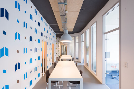 Modern coworking office with communal desk and geometric wall