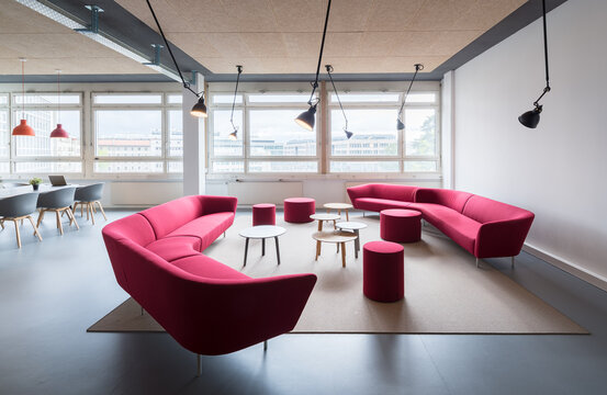 Modern coworking office lounge with pink curved sofas