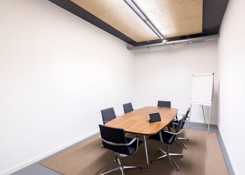 Modern coworking meeting room with table and presentation board