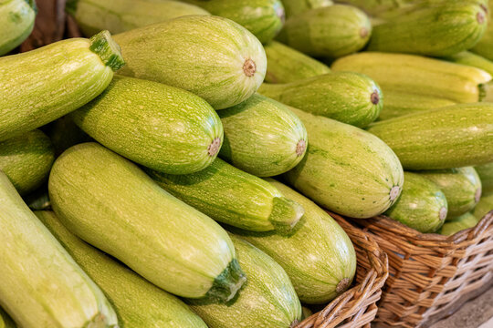 Fresh zucchini squash piled in a woven market basket