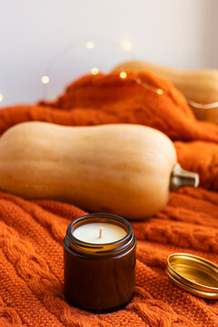 Autumn still life with candle, pumpkin and orange sweater