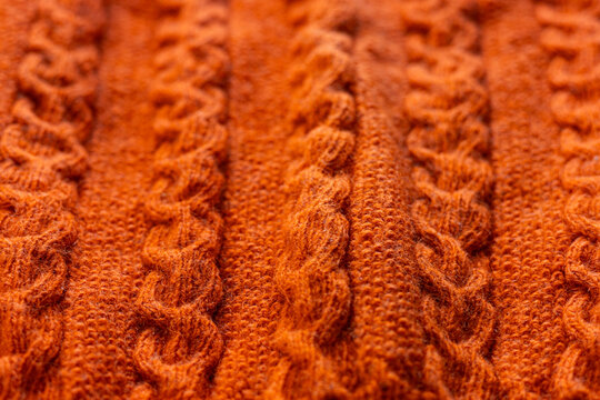 Orange cable knit sweater texture close-up background