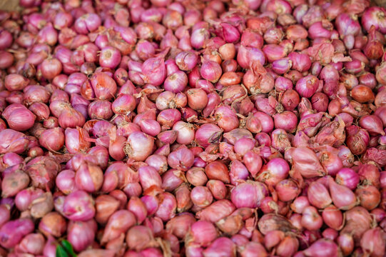 Red shallot pile at a traditional market stall