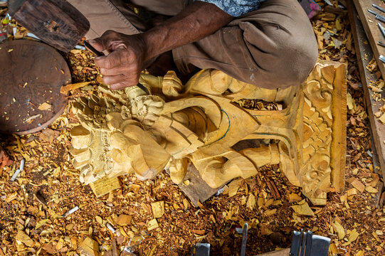 Balinese artisan carve wooden Garuda sculpture by hand
