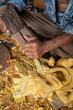Balinese artisan carve a traditional wooden sculpture