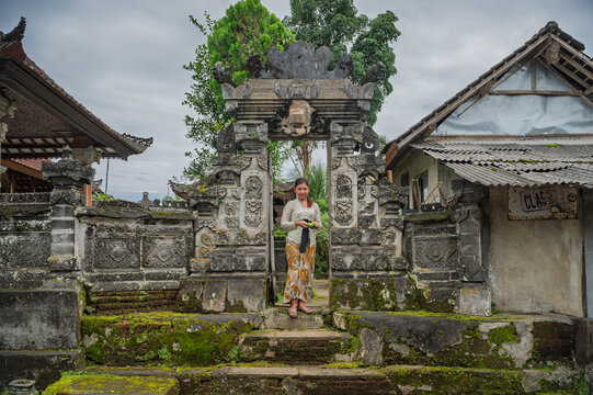 Balinese woman at historic temple gate in Bali