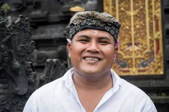 Smiling Balinese man in traditional headwear at temple