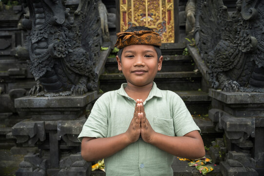 Balinese boy praying at traditional Hindu temple entrance