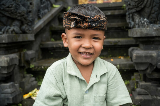 Smiling Balinese boy in traditional udeng at temple