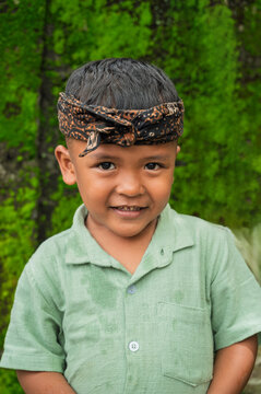 Smiling Indonesian boy in traditional headband portrait