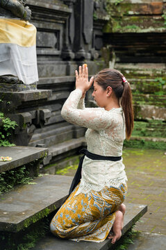 Balinese woman pray at Hindu temple in traditional attire