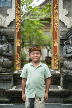 Balinese boy at traditional temple entrance in Indonesia