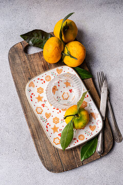 Christmas orange decoration on festive plate and wooden tray