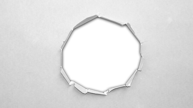 Gray circular torn paper hole with rough edges and transparent center, neutral cutout punch shape for minimalist collage and graphic design