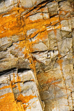 Orange mineral stain on fractured sedimentary rock texture