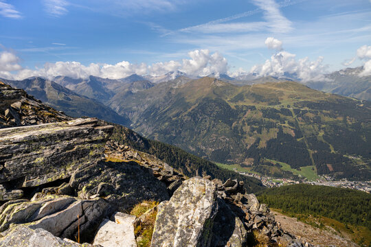 Panoramic alpine mountain valley under blue summer sky