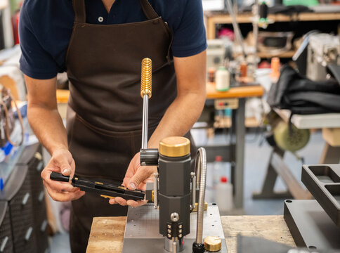 Shoemaker operate machinery in a handcrafted shoe workshop