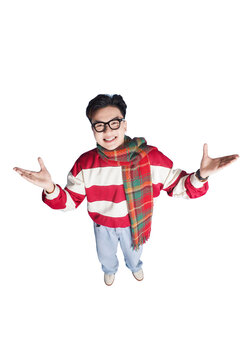 Excited Young Man with Glasses: A joyful young man with glasses, wearing a striped sweater and scarf, smiles widely with his arms outstretched, conveying enthusiasm and excitement.