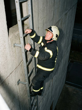 Firefighter climbing a training tower ladder