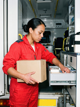 Paramedic restocking an ambulance drawer